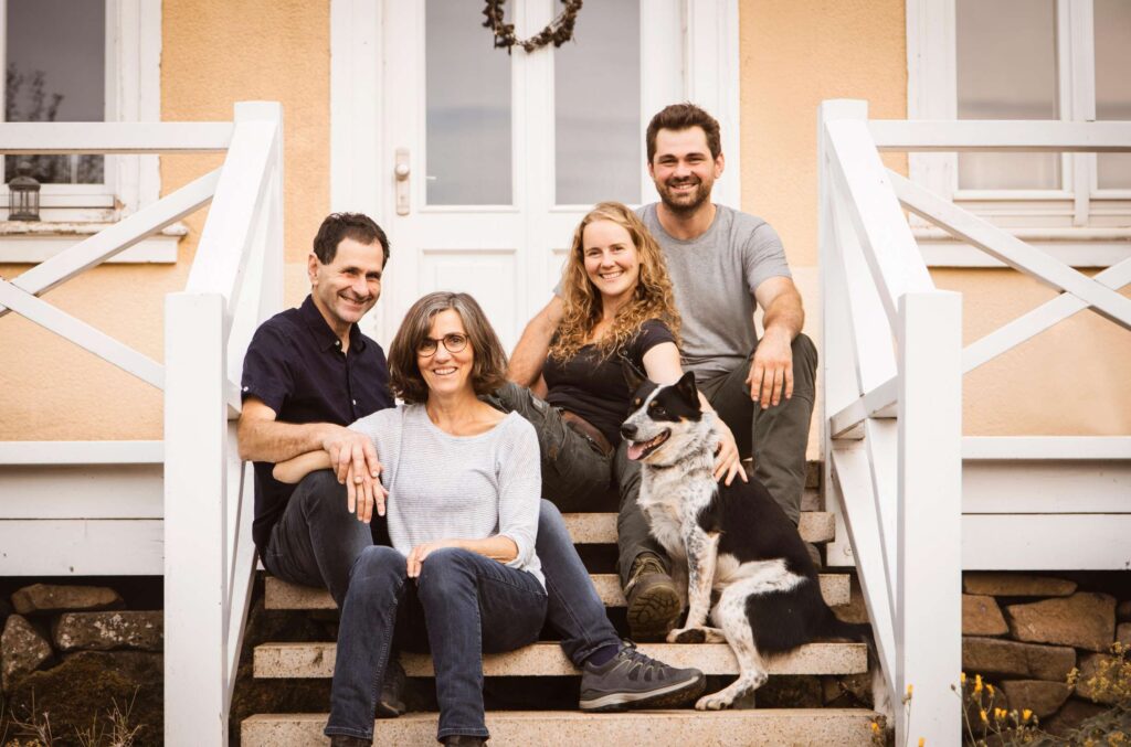 Eine Familie sitzt auf einer Treppe mit ihrem Hund.