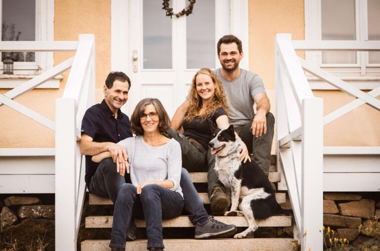 Eine Familie sitzt auf einer Treppe mit ihrem Hund.