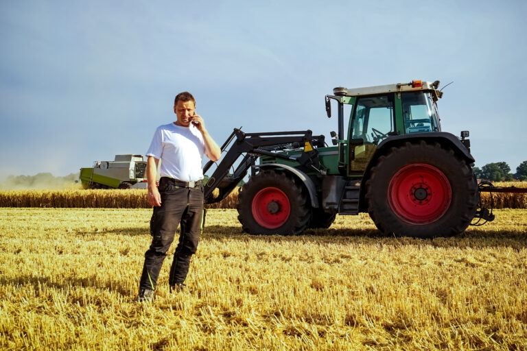 Getreideernte, landwirt telefoniert auf dem getreidefeld